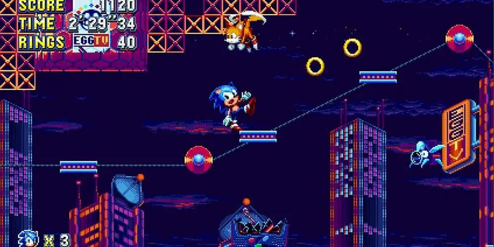 Sonic trong Sonic Mania đang mất thăng bằng bên rìa một nền tảng, phía xa là một thành phố đèn neon rực rỡ