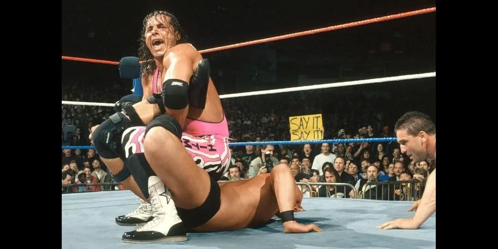 Bret Hart thực hiện đòn Sharpshooter khóa chặt Stone Cold Steve Austin đang chảy máu