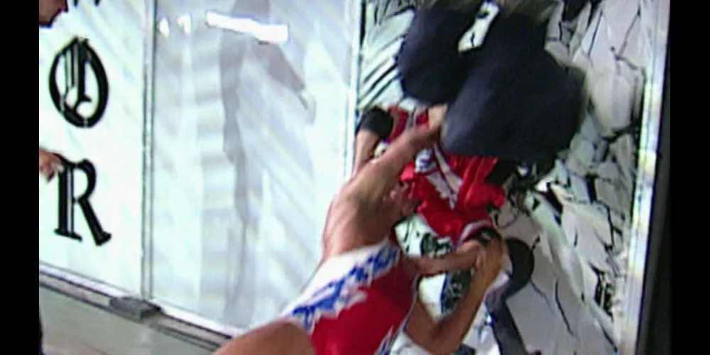 Shane McMahon bị Kurt Angle suplex vào tấm kính