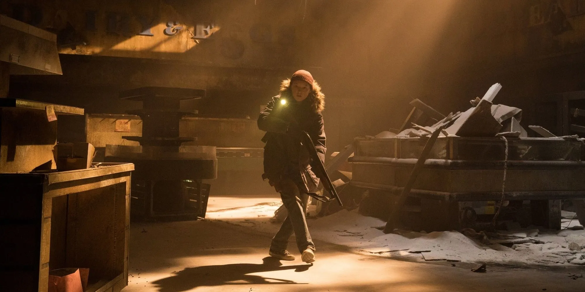 Ellie đang cầm súng và đi qua một tòa nhà đổ nát trong The Last of Us Mùa 2.