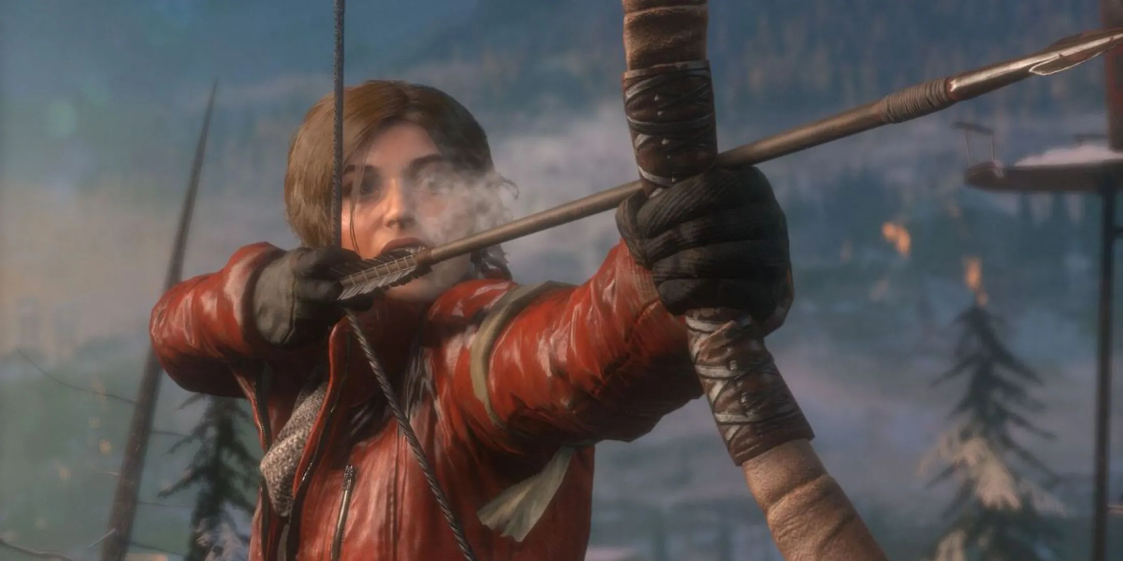 Lara Croft đang nhắm cung tên trong một khu rừng phủ đầy tuyết trong Rise Of The Tomb Raider