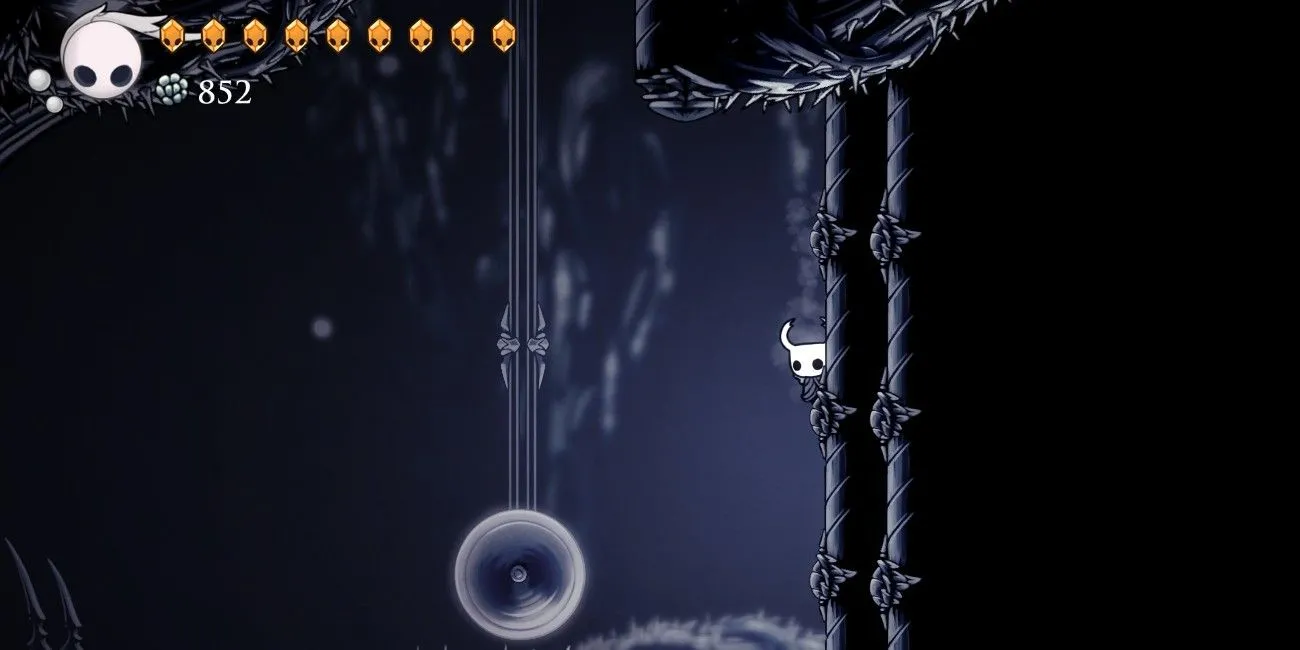 Knight treo tường trong đoạn Path of Pain của Hollow Knight với các chướng ngại rất sát